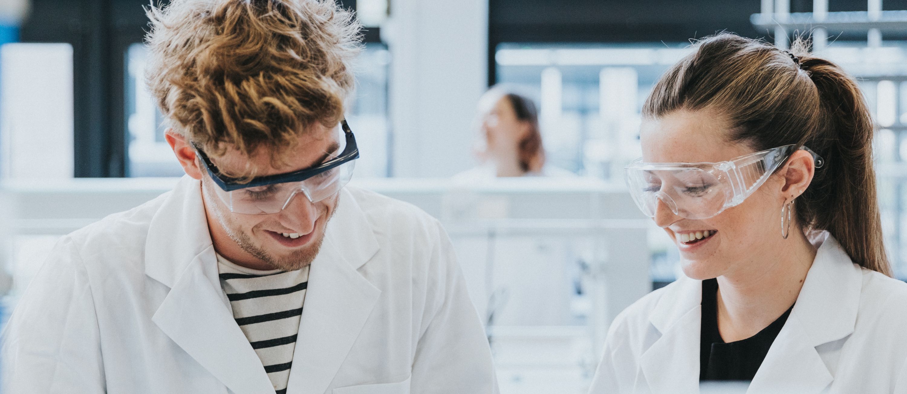 studenten voedings- en dieetkunde met beschermingsbril en labojas